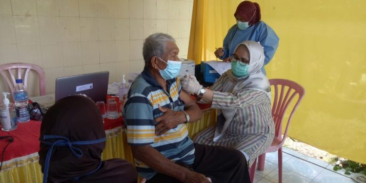 Petugas kesehatan menyuntik vaksin salah seorang warga saat gebyar vaksin di Kelurahan Ampang, Kota Padang, beberapa waktu lalu. PUTRI WULANDARI