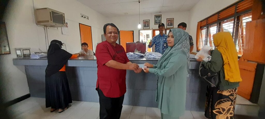 Kepala Cabang Pos Biaro UPT Bukittinggi, Irvan Agus menyerahkan bantuan BLT BBM kepada penerima bantuan di Kantor Pos setempat, Jumat (9/9/2022). Yursil