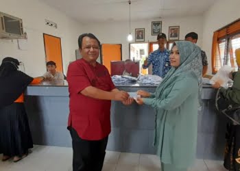 Kepala Cabang Pos Biaro UPT Bukittinggi, Irvan Agus menyerahkan bantuan BLT BBM kepada penerima bantuan di Kantor Pos setempat, Jumat (9/9/2022). Yursil