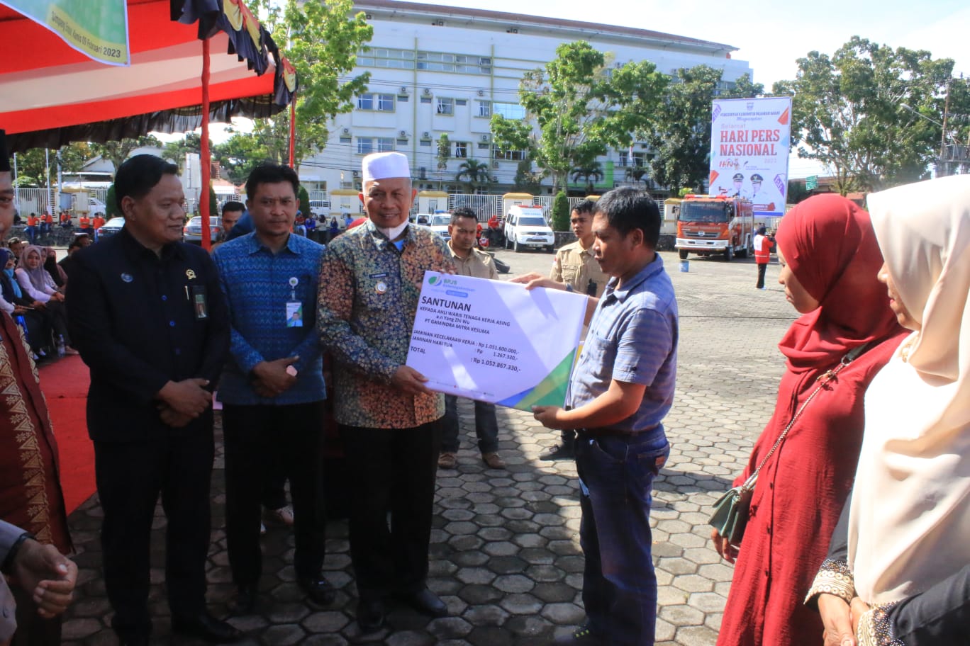 Salah seorang ahli waris menerima santunan dari BPJS Ketagakerjaan pada perayaan hari K3. Osniwati