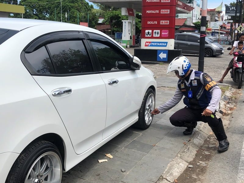 Tindak kendaraan parkir di trotoar, Kamis (23/2), Dishub lakukan pengempesan ban. DARWINA
