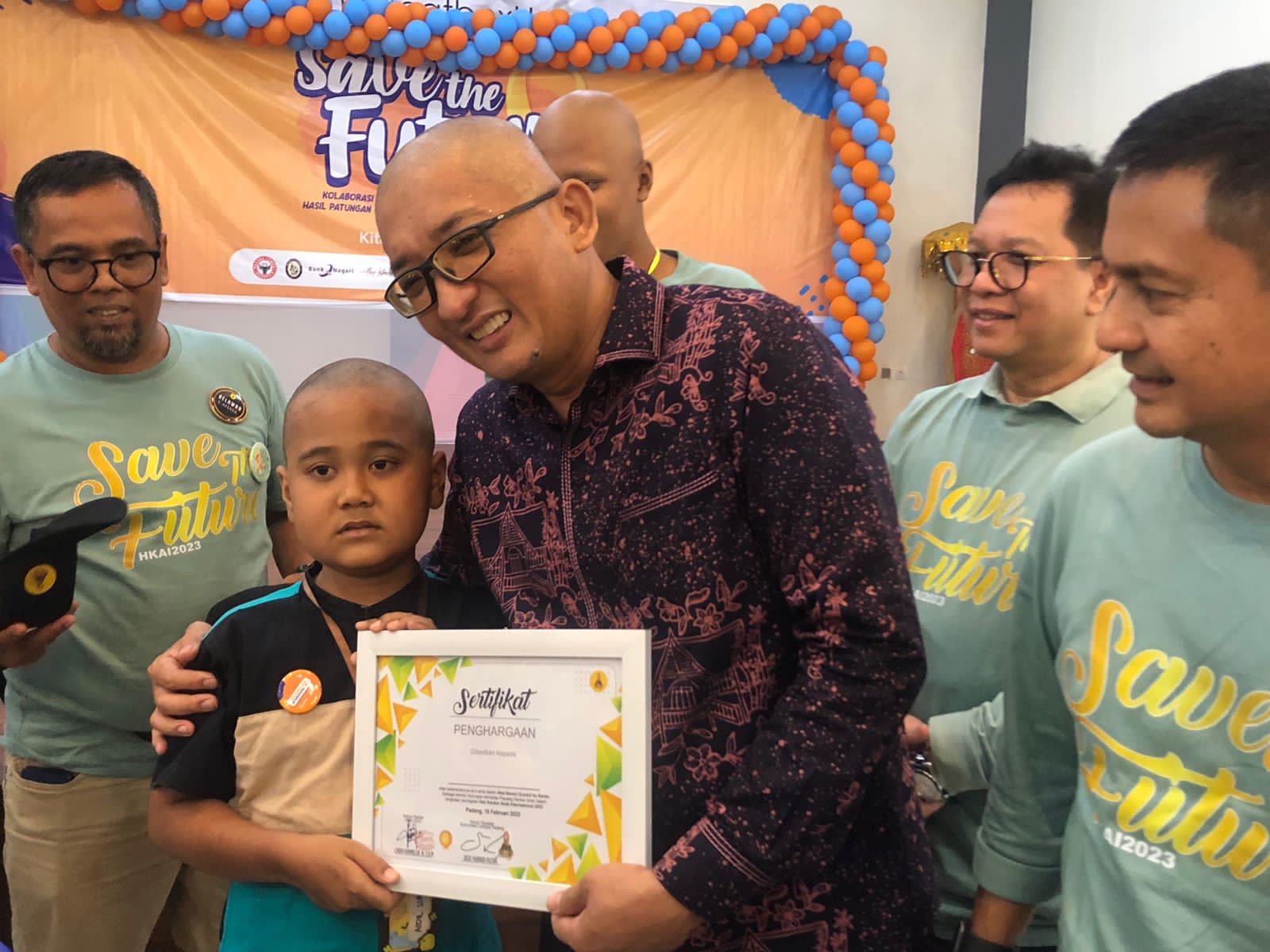 Wali Kota Padang Hendri Septa, rela gundul dan berfoto dengan salah seorang anak penderita kanker, saat menghadiri Hari Kanker Anak Internasional 2023 di Youth Center Padang. Minggu, (19/2). DARWINA.