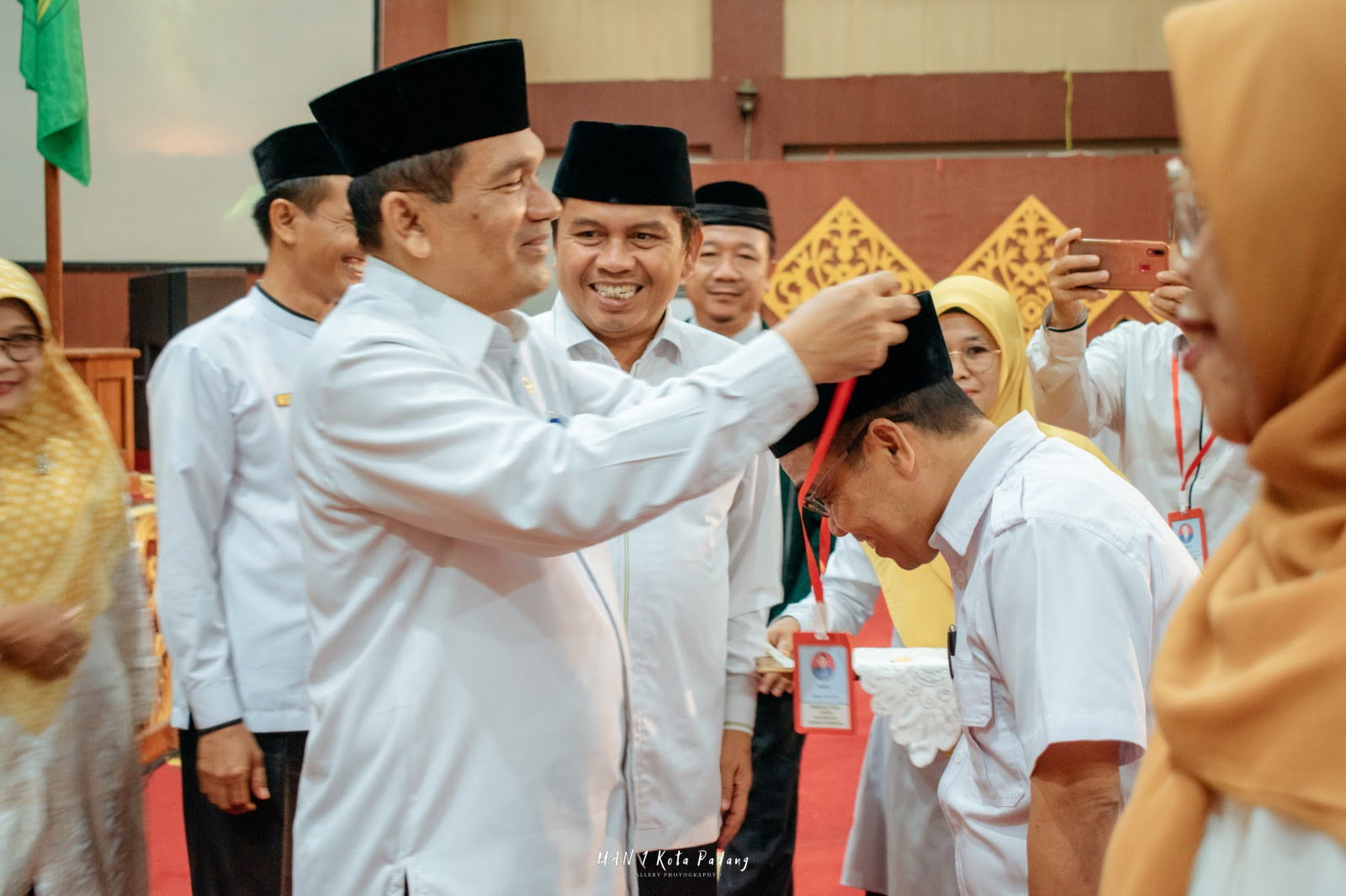 Kepala Kantor Wilayah Kementerian Agama Provinsi Sumatera Barat, Helmi memasangkan tanda peserta bimtek kepada dua perwakilan peserta. PUTRI MERI YANTI PERTIWI