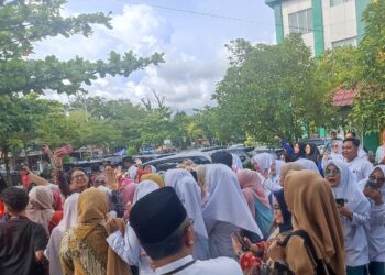 Foto : Menteri Kesehatan RI, Budi Gunadi Sadikin dikerumuni mahasiswa yang ingin berswafoto saat mengunjungi Poltekkes Kemenkes Padang, Jumat (23/2). YESI