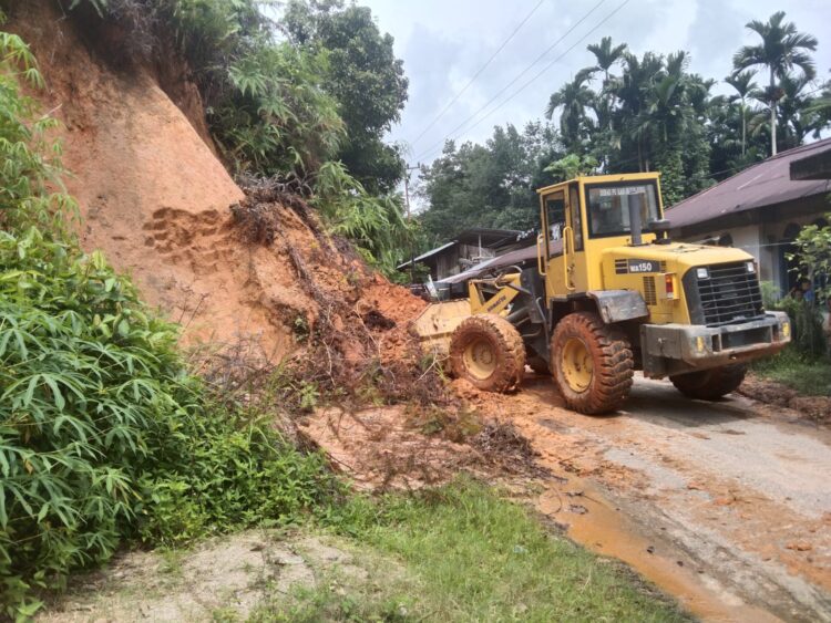 Alat berat milik Dinas PUPR Kabupaten Sijunjung saat membersihkan material longsor dari jalan utama warga yang  pagi di jorong Koto Mudiak Nagari Durian Gadang Kecamatan Sijunjung beberapa waktu lalu.