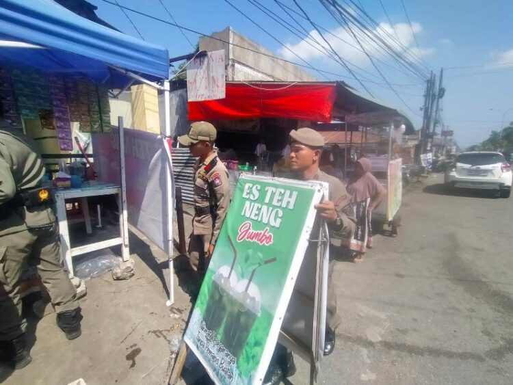 Anggota Satpol PP Padang menertibkan barang-barang PKL yang berjualan di depan kampus UPI, Rabu (3/7). IST