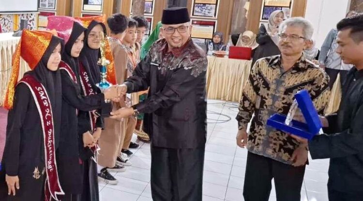 Kabid Kebudayaan Disdikbud Kota Bukittinggi Heru Triastanawa serahkan piala kepada juara LCCM Tingkat SMP Se-Kota Bukittinggi tahun 2024 di Istana Bung Hatta Bukittinggi pekan lalu. Ist