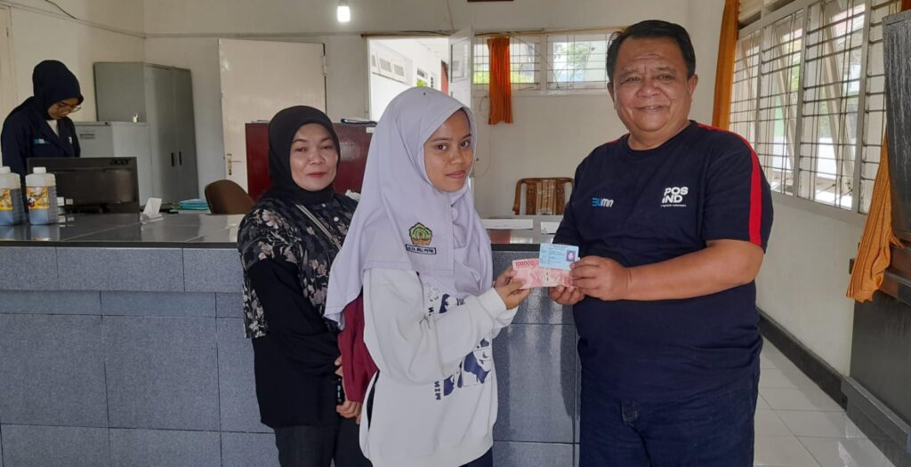 SERAHKAN BANTUAN YAPI - Kepala KCP Pos Ind Biaro, Irfan menyerahkan bantuan Yapi kepada penerima di Kantor Pos Biaro, Selasa (12/11).