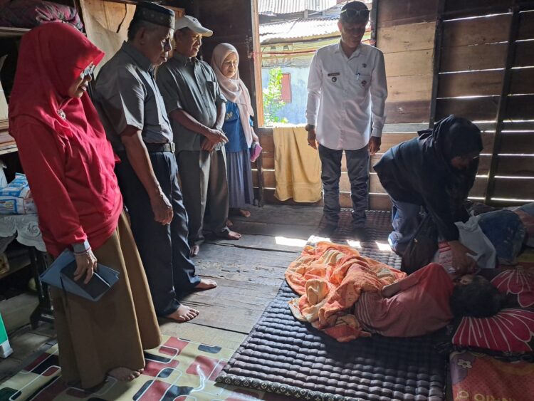 Lurah Alai Parak Kopi Afrimen S.Sos., saat menyalurkan bantuan pada warga kurang mampu yang tidak menerima PKH atau Bansos di wilayahnya beberapa waktu lalu. IST