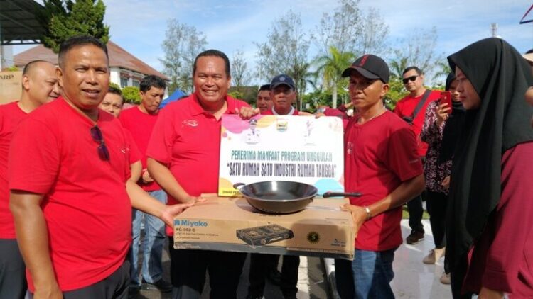 Yota Balad didampingi Mulyadi menyerahkan bantuan kompor gas dan teflon kepada pelaku usaha, Jumat (29/8). MITHA