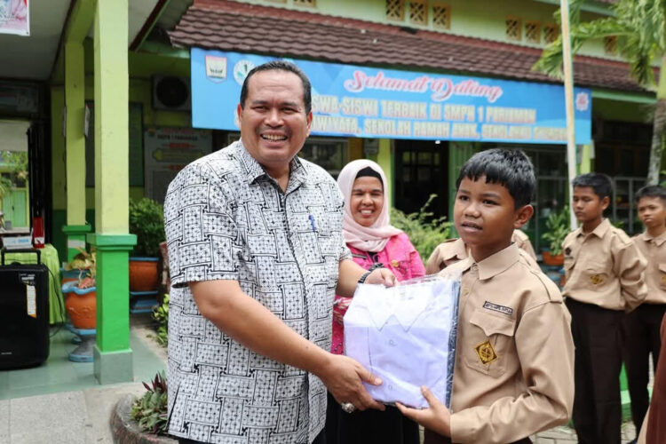 Wali Kota Pariaman, Yota Balad, menyerahkan seragam sekolah gratis kepada siswa Sekolah Menengah Pertama (SMP) se-Kota Pariaman. IST