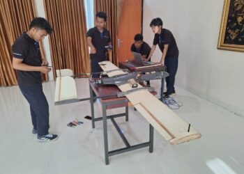 Ketua Dewa Manggala Team, Pradipta Septrian Jati (di tengah) selaku peserta KRTI sedang mempersiapkan pesawat yang akan dilombakan, Rabu (15/10) kemarin. IST