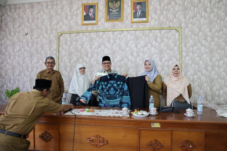 Ketua DPRD Provinsi Sumatera Barat (Sumbar) Muhidi menyerahkan bantuan baju batik kepada para guru di empat sekolah, yakni SMA Negeri 1 Padang, SMA Negeri 2 Padang, SMA Negeri 10 Padang, dan SMA Negeri 3 Padang, Selasa (14/10). IST