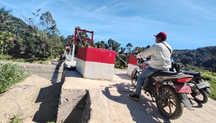Warga melewati Jembatan Perintis Merah Putih yang didirikan Personel Kodim Lubuk Basung beberapa waktu lalu.